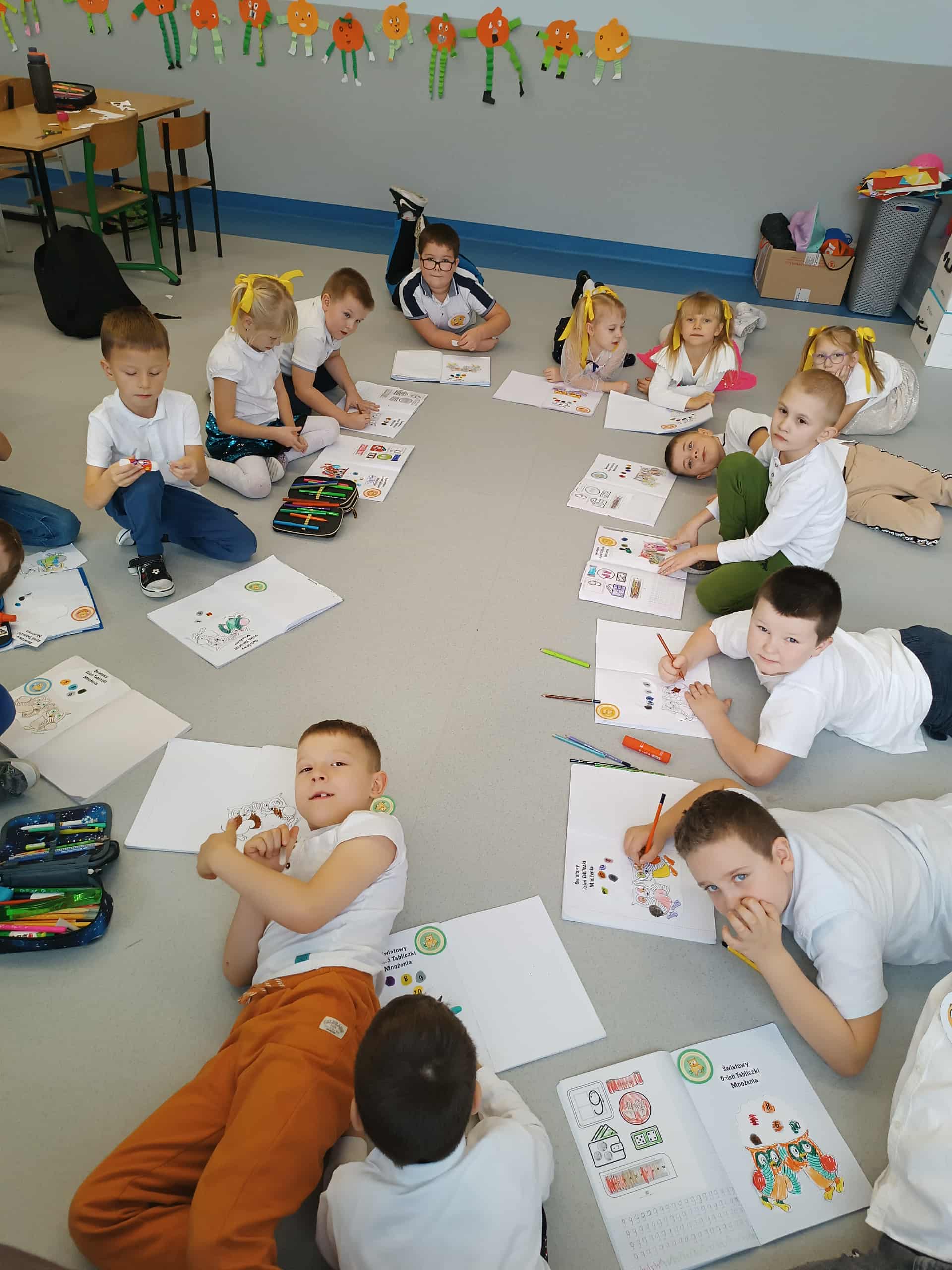 Uczniowie młodszych klas kolorują sowę symbol mądrości podczas dnia tabliczki mnożenia.