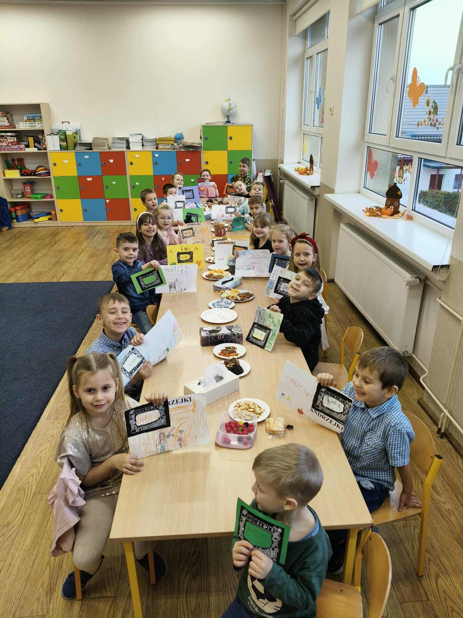 Uczniowie siedzą w ławkach i prezentują swoje prace na temat Andrzejek.