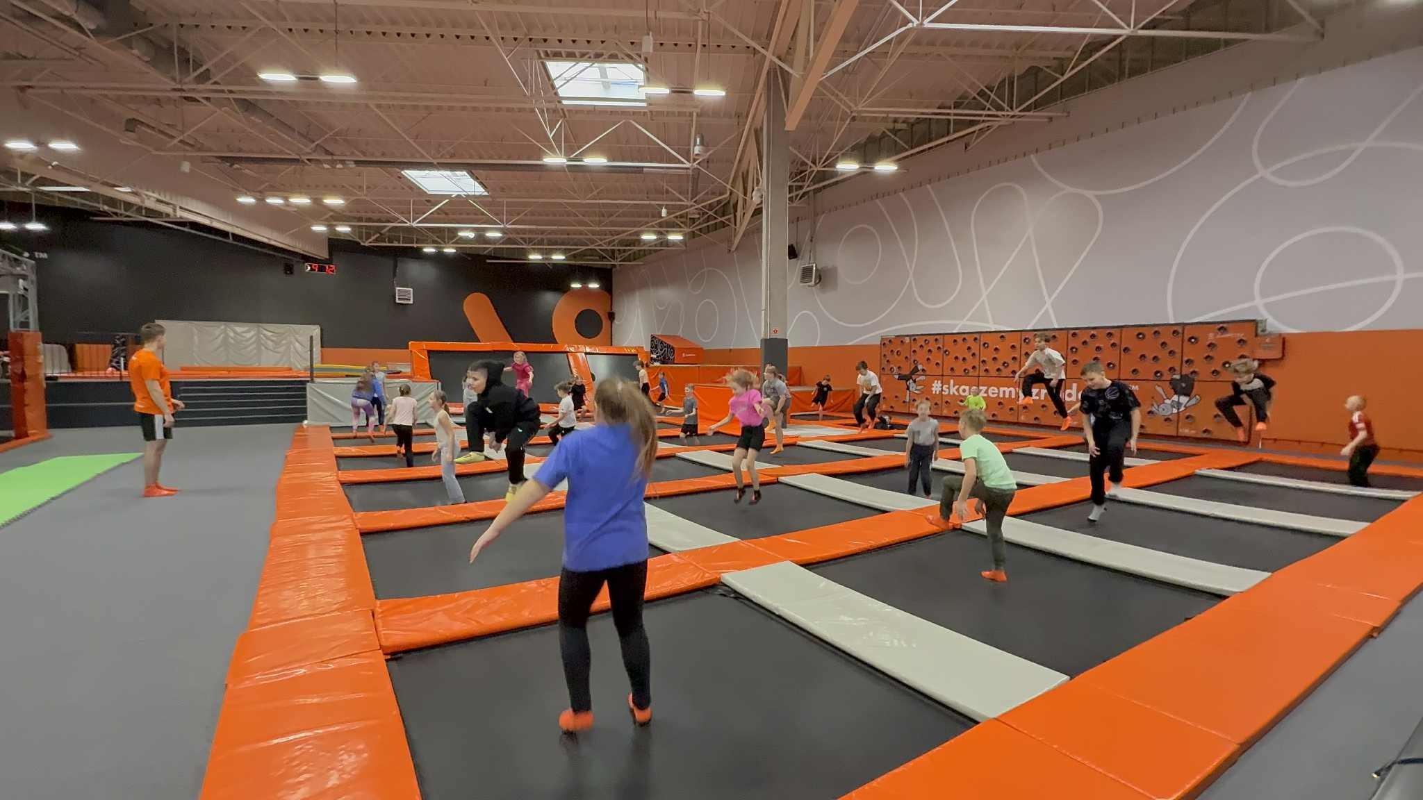 Uczniowie skaczą na trampolinach.