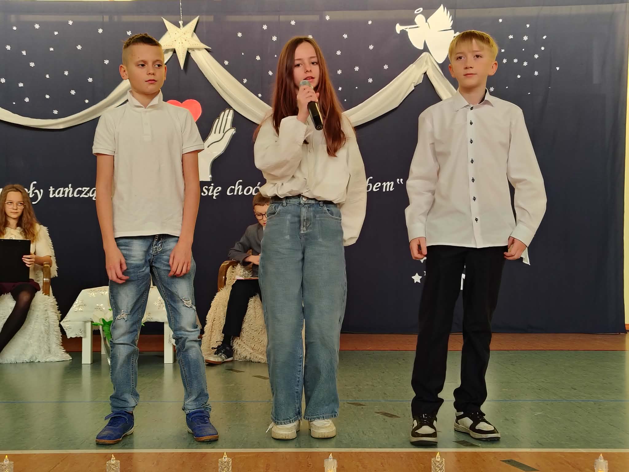 Trio uczniów podczas recytacji wiersza.