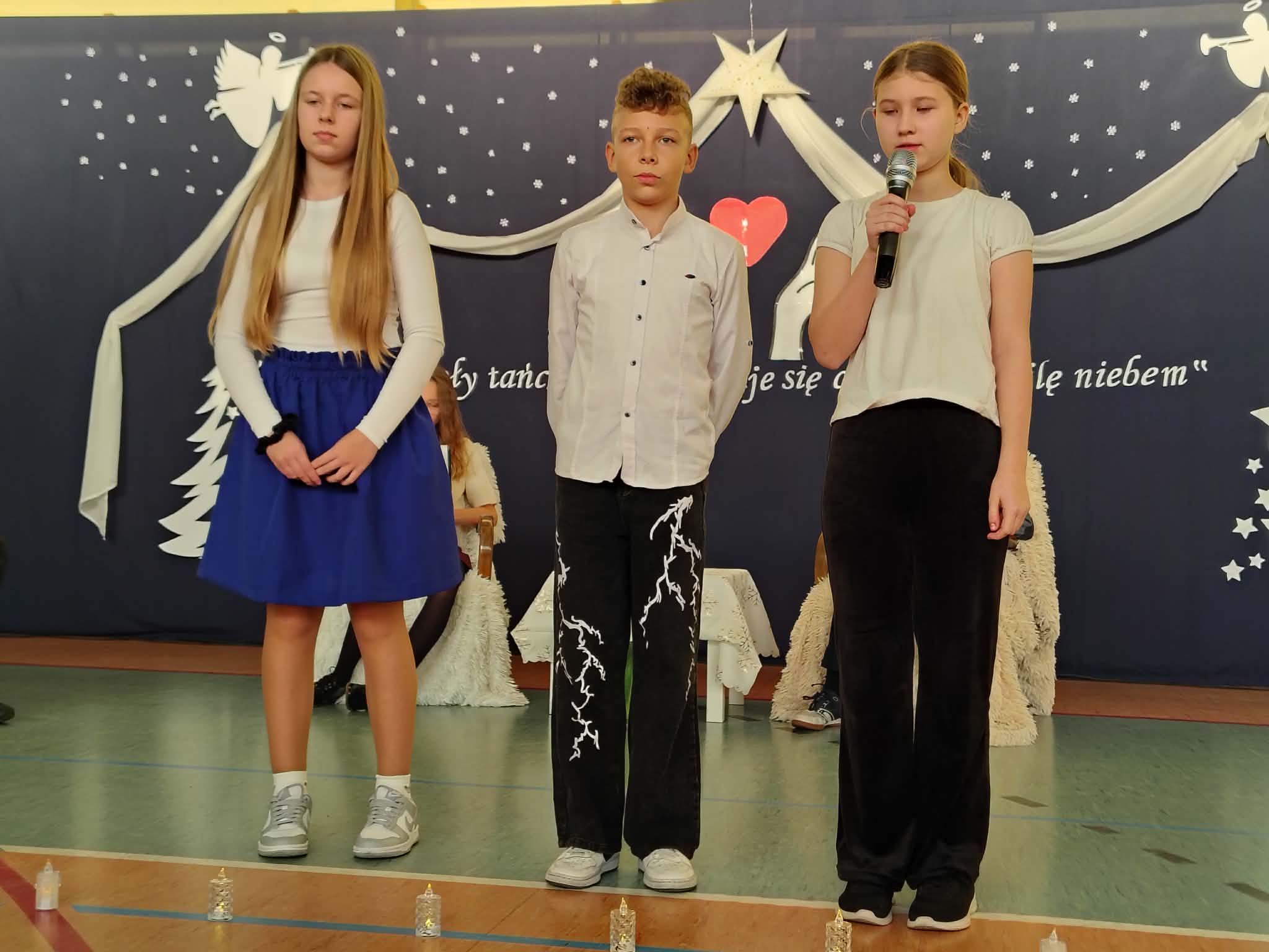 Trio uczniów podczas recytacji wiersza.