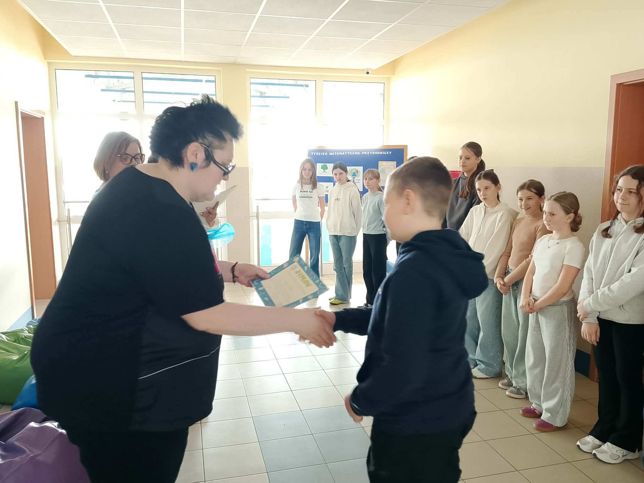 Pani Dyrektor wręcza dyplom i upominek uczniowi.