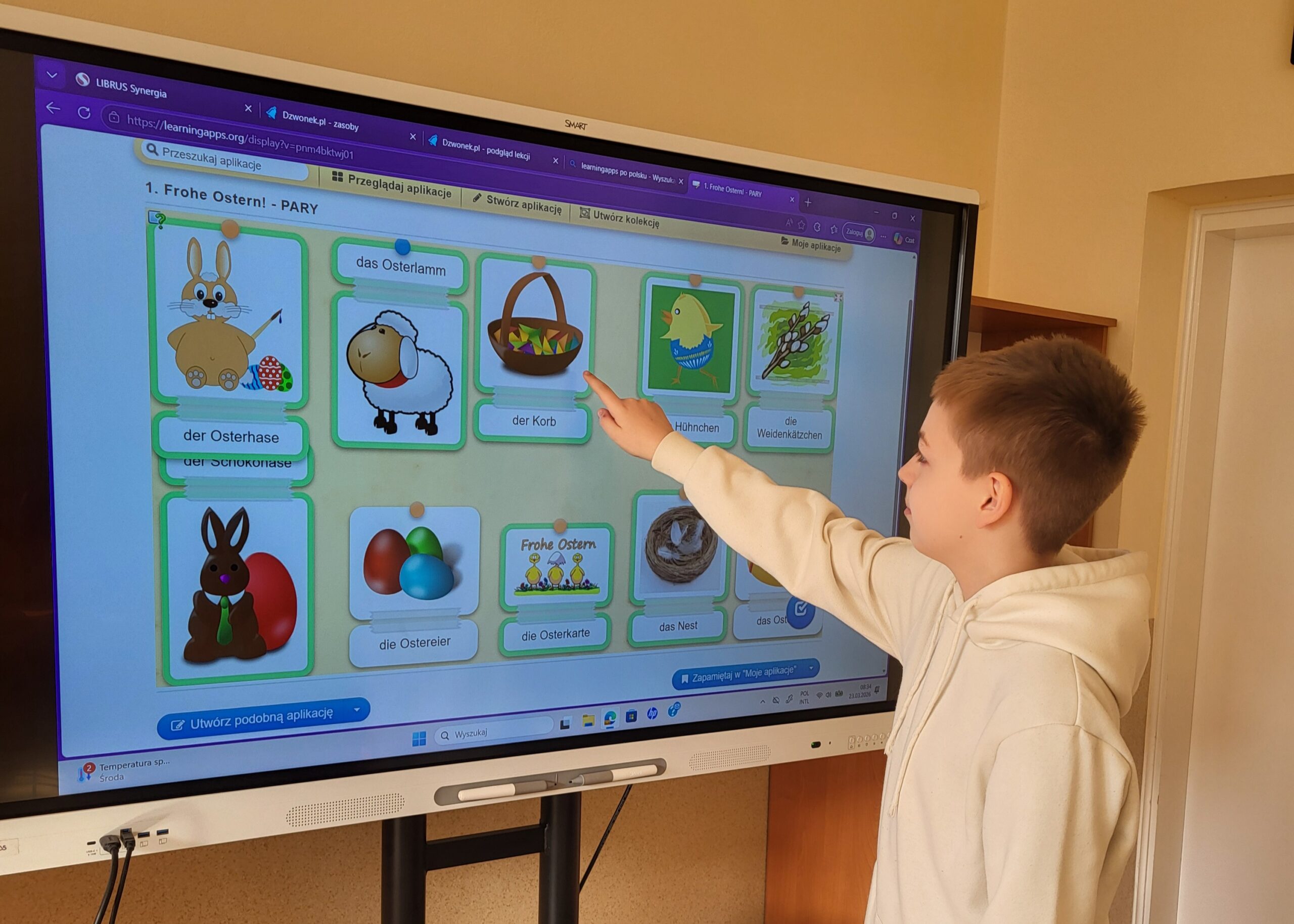 Uczeń klasy Vb pokazuje elementy związane ze Świętami Wielkanocnymi na tablicy interaktywnej