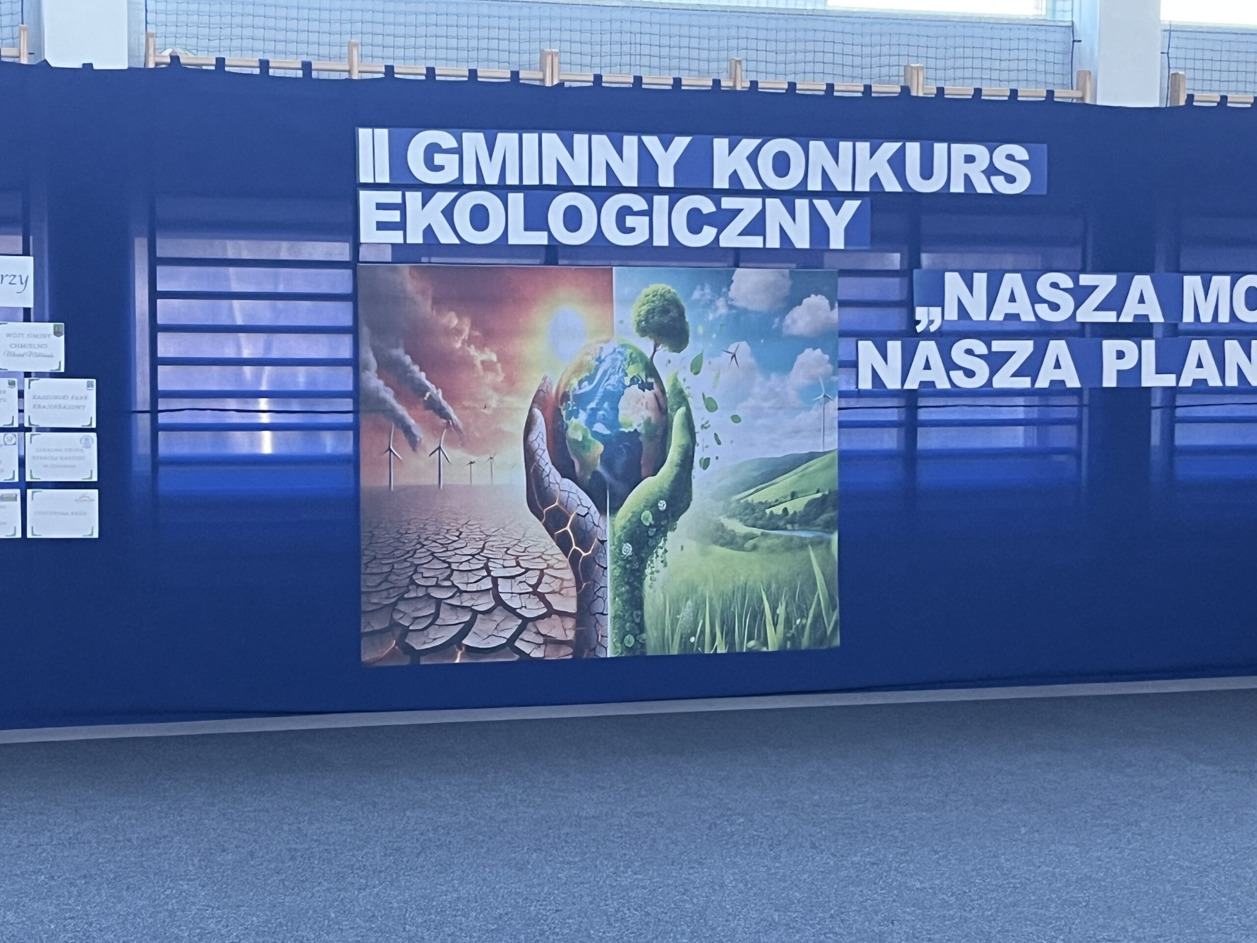 Dekoracja ścienna konkursu ekologicznego, kula ziemska trzymana na dłoni.