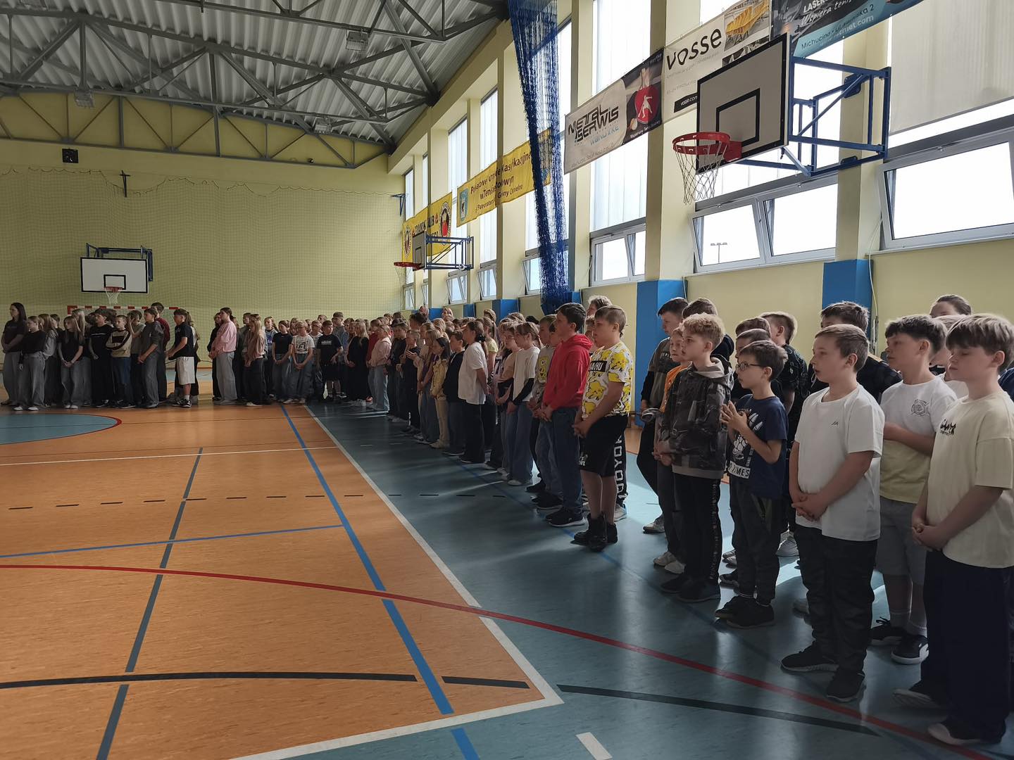 Uczniowie naszej szkoły stoją w równym rzędzie podczas apelu poświęconemu ks. Piotrowi.
