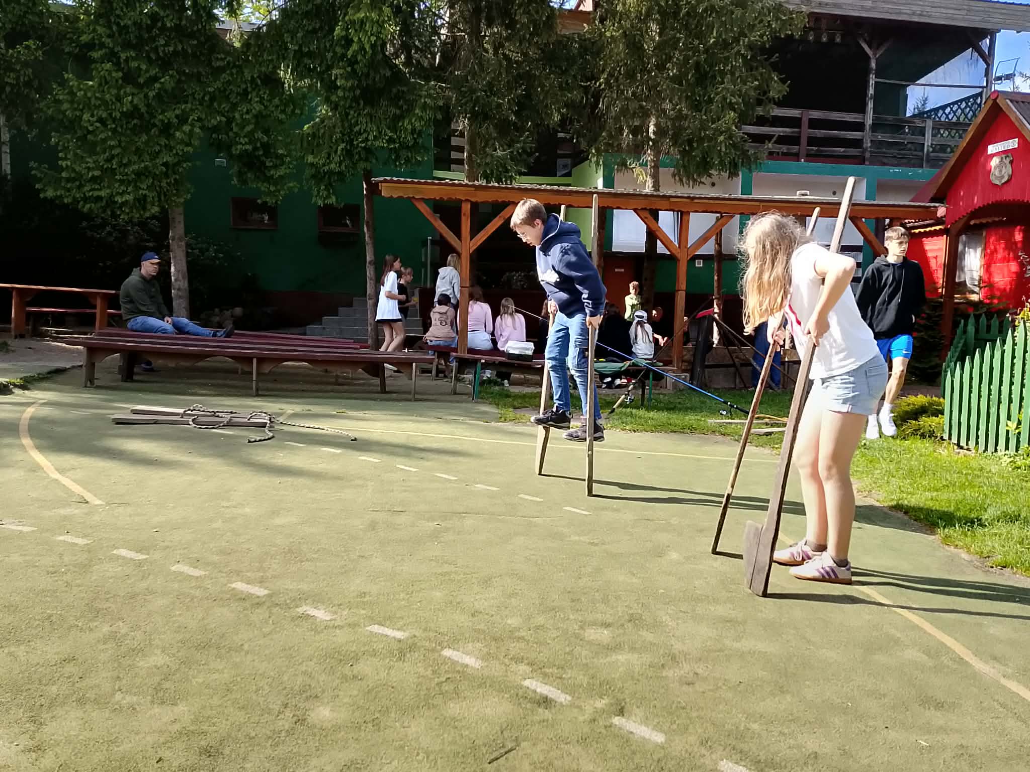 Dwóch uczniów chodzi na szczudłach.