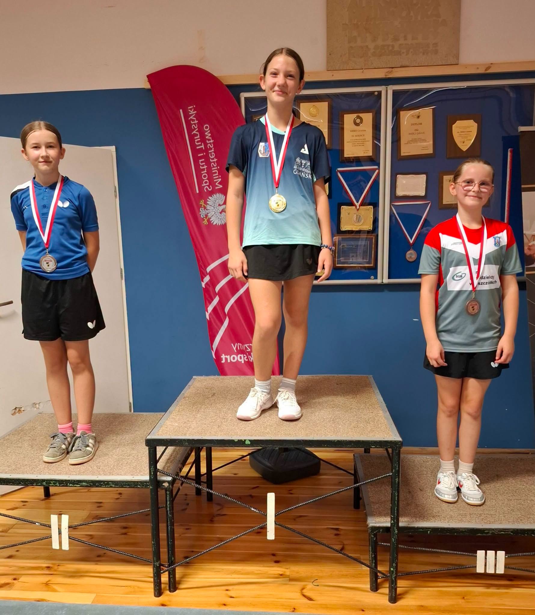 Uczennice stoją na podium.