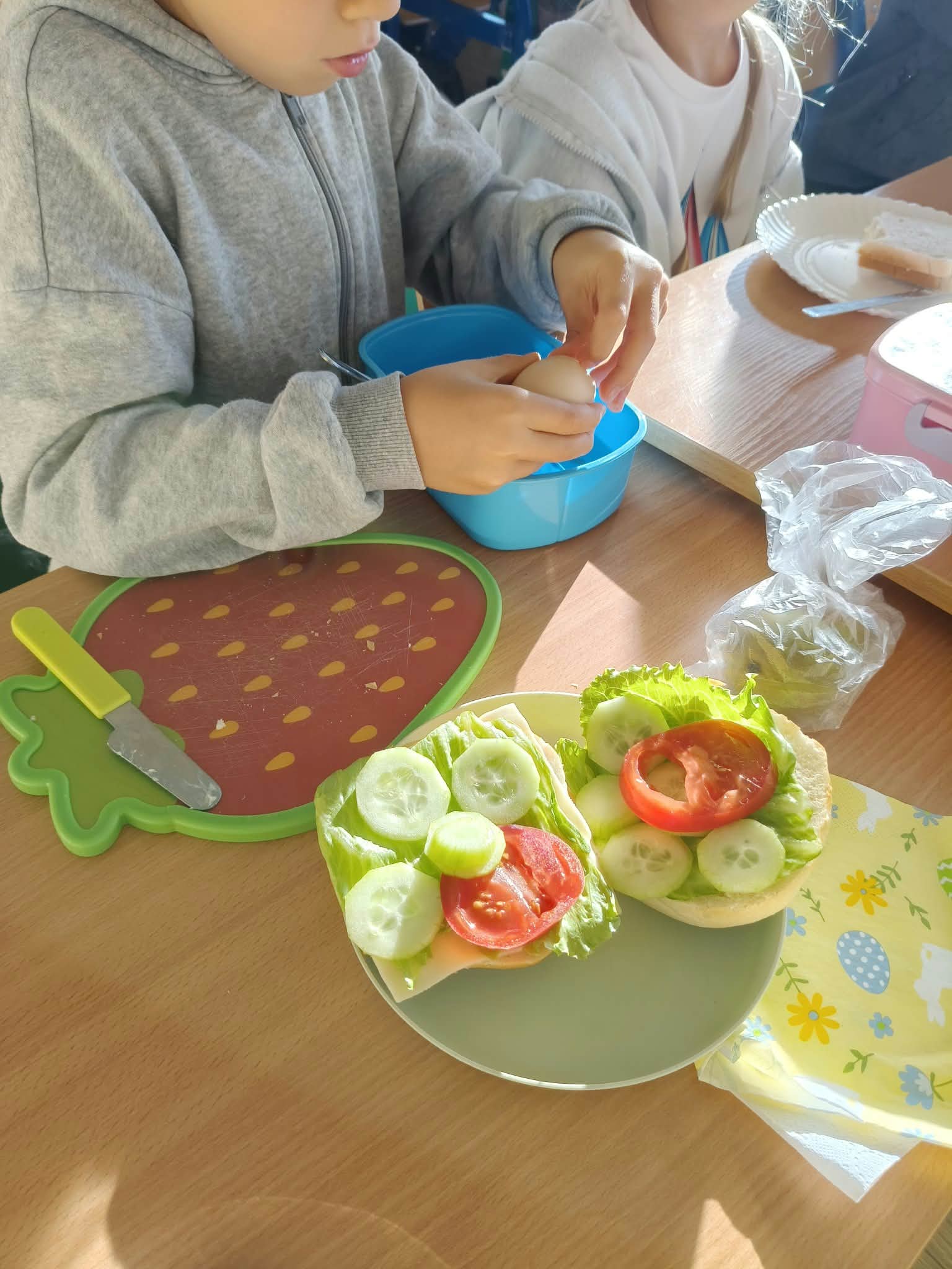 Uczeń skubie ugotowane jajko do przygotowania zdrowej kanapki.